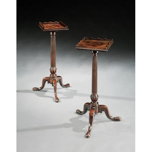 A near pair of mahogany urn stands
